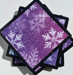 four square coasters with snowflakes on them