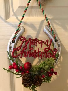 a metal horseshoe hanging from a door decorated with christmas decorations