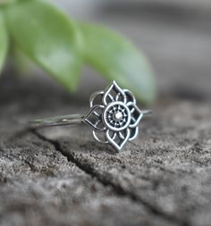 a close up of a ring on a wooden surface with a plant in the background