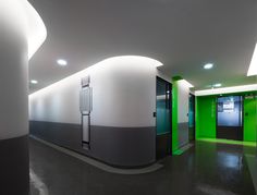 an empty room with green and white walls in the center is lit by recessed lights