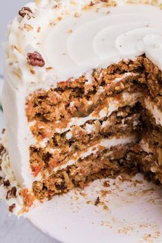 a close up of a cake with white frosting and pieces cut out of it