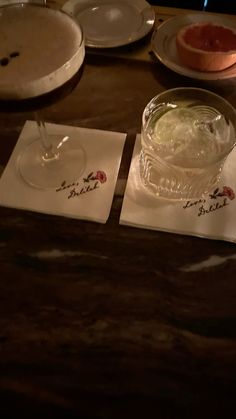 three plates and two glasses on a table with writing on them, one has a wine glass in the middle