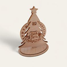 a wooden christmas tree with the words days until christmas written in red and white on it