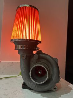 a red light sitting on top of a table next to a blow dryer fan