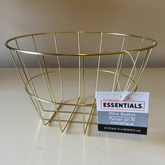 a wire basket sitting on top of a table next to a price label for wine baskets