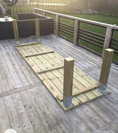 a wooden deck with metal posts and benches