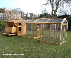 a wooden chicken coop in the grass