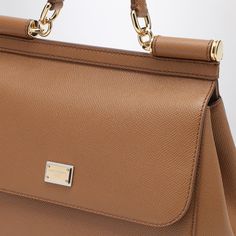 Medium handbag by Dolce & Gabbana in caramel grained leather, featuring frontal flap, hidden snap closure, handle, adjustable and removable shoulder strap, label with logo, internal zip pocket with logo, pocket for the smartphone and metal feet.Width 26 cm x Height 21 cm x Depth 12 cm Adjustable shoulder strap length min 103 cm - max 120 cm Handle drop: 8 cm100% Calf leather Designer Cognac Satchel With Detachable Handle, Luxury Brown Flap Bag With Removable Pouch, Designer Brown Flap Bag With Detachable Handle, Saffiano Leather Satchel With Handles, Designer Cognac Satchel With Handle Drop, Saffiano Leather Satchel Bag With Handles, Designer Everyday Flap Bag With Handles, Luxury Cognac Satchel With Detachable Strap, Designer Cognac Satchel