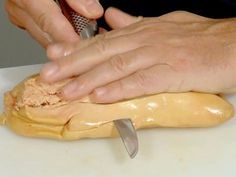 a person is using a knife to cut something on a piece of bread that has been kneaded