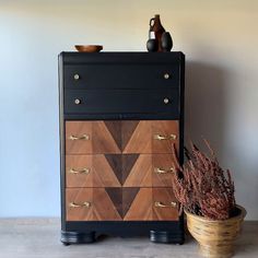 a wooden dresser sitting next to a potted plant