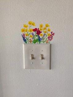 an electrical outlet with flowers painted on it