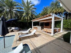 an outdoor patio with lounge chairs and umbrellas