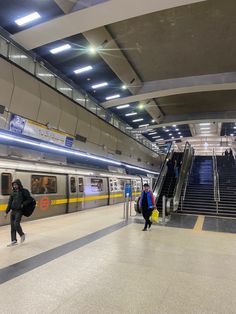 people are walking up and down an escalator in a train station with stairs