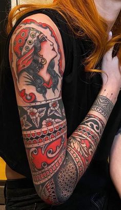 a woman with red hair and tattoos on her arm