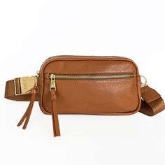 Whether you're walking around town, at a sporting event, or out to dinner, the Hampton is perfect for when you want to be hands-free. It fits all your essentials and has an adjustable strap to go from crossbody to waist bag for two looks in one! HIGHLIGHTS Dune Tan color Luxury genuine perforated leather  9.5" W X 5.5" H X 2.5" D Shore Pine green lining Custom gold hardware with solid metal buckle Exterior front pocket: perfect for your phone or keys Interior card slot Interior leather trimmed p Travel Crossbody Chest Bag With Detachable Strap, Versatile Belt Bag With Adjustable Strap For Travel, Crossbody Belt Bag With Adjustable Strap For On-the-go, Sporty Crossbody Chest Bag With Adjustable Strap, Brown Shoulder Bag With Adjustable Strap For Commuting, Casual Belt Bag With Detachable Strap For Travel, Sporty Shoulder Belt Bag For Travel, Functional Brown Crossbody Belt Bag, Travel Crossbody Belt Bag With Detachable Strap