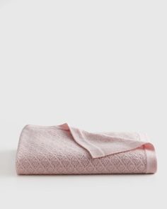 a pink towel folded on top of a white table