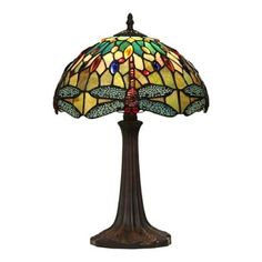 a lamp that is sitting on top of a wooden stand with a dragonfly design on it