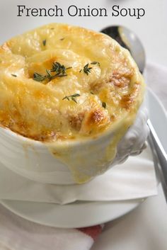 a close up of a bowl of food on a plate with a spoon and fork