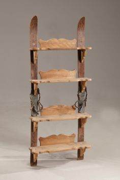 a wooden shelf with two pairs of skis hanging from it's bottom shelves