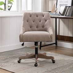 an office chair sitting on top of a rug in front of a desk and window