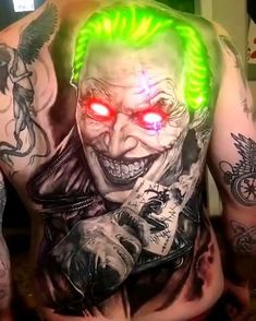 the back of a man's body with tattoos on it, and glowing red eyes