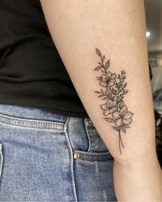 a woman's arm with a flower tattoo on the left side of her arm