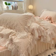 a bed with white ruffled bedspread and pillows