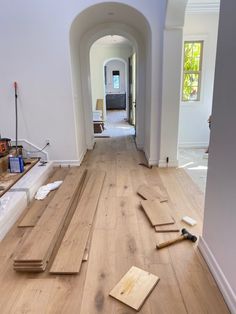 a hallway with hard wood flooring and tools on the ground in front of it