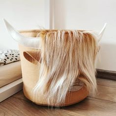 an animal's head is sitting on the floor next to a basket with long hair