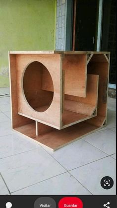 a wooden box sitting on the ground in front of a green wall with a door