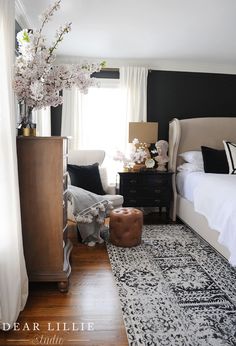 a bedroom with black walls and white furniture