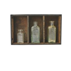 three glass bottles in a wooden box