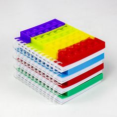 a stack of colored legos sitting next to each other on a white table top