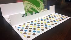 an open folder with polka dots on the inside is sitting on top of a table