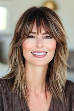 Save this pin for the best hairstyles for women over 40 with thin hair. Piecey layers create a look of thickness in this medium-length shag haircut. The wispy bangs add a youthful touch without overwhelming your features. Medium Shag With Wispy Bangs, Medium Length Haircut For Thick Hair With Layers Bangs, Thick Bangs With Medium Hair, Whisky Bangs Medium Hair, Bangs Over 50 Medium Hair, Medium Length Haircut With Bangs Over 40, Medium Length Hair With Bangs Over 40, Light Brown Medium Length Hair