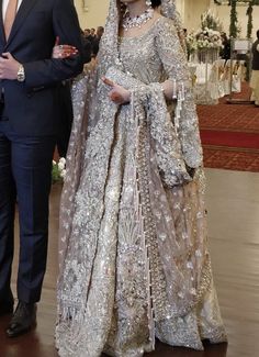 a man in a suit and tie standing next to a woman in a wedding dress