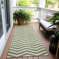 a green and white rug sitting on top of a wooden floor next to a window