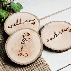 three personalized wood slices with the names of their loved ones on them are sitting next to each other