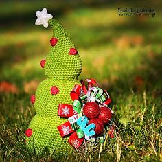 a knitted christmas tree sitting on top of green grass