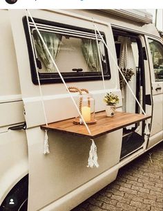 a camper van with a wooden table attached to it