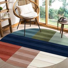 a room with a chair, table and rugs in different colors on the floor