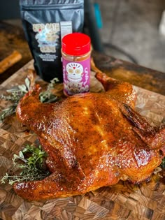 a whole chicken sitting on top of a wooden cutting board next to a bag of seasoning