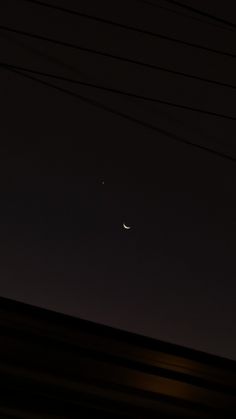 the moon and venus seen through power lines at night