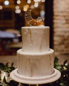 a three tiered white cake with gold decorations on top and the words brides above it