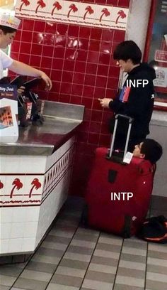 two young boys standing in front of a counter with luggage