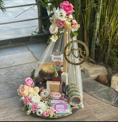 a vase filled with lots of flowers on top of a wooden table next to plants