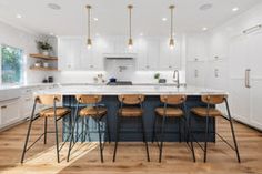 a large kitchen with an island and bar stools