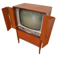 an old fashioned television sitting on top of a wooden cabinet