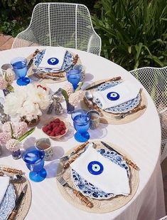 an outdoor table set with blue and white dishes