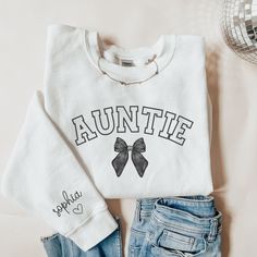 This custom aunt sweatshirt is a great gift for an aunt or new aunt to be! This sweatshirt can be given as a gift to a friend or loved one. This sweatshirt is made with the highest quality materials and is super comfy, soft and cozy!! Please enter the name(s) of child(ren) you would on the sleeve in the personalized section. ABOUT THIS ITEM: - Gildan Sweatshirt - Long Sleeve Crew Neck - Ribbed Neck Collar - Double-Needle Stitching - Not Vinyl Printing - Shirt is direct to fabric print (DTF) - Ma Auntie And Nephew Shirts, Aunt Sweatshirt Ideas, Auntie Shirt Ideas, Vinyl Sweatshirt Ideas, Auntie Sweater, Nephew Shirts, Auntie Sweatshirt, Aunt And Niece, Aunt To Be